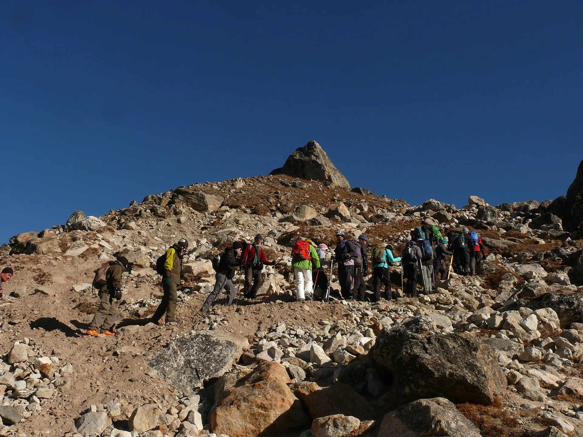 Trekkers climbing a rocky ridge above the Khumbu Valley
